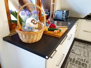 a kitchen counter with a basket of vegetables and a sink at Seeperle 4 in Meersburg +30 photos