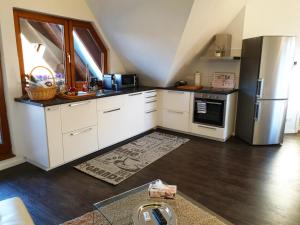 a kitchen with white cabinets and a stainless steel refrigerator at Seeperle 4 in Meersburg