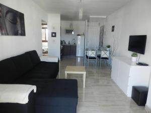 sala de estar con sofá negro y cocina en Apartment Bellavista 36 Cabo Roig, en Cabo Roig