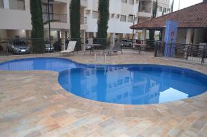 a large blue swimming pool in a courtyard at Olímpia Temporada Cond. Villagio in Olímpia
