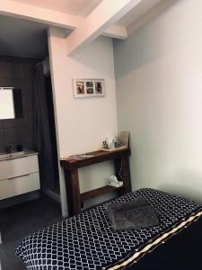 a bedroom with a bed with a table and a sink at Allegria Nîmes in Nîmes