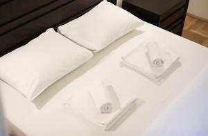 Una cama blanca con dos almohadas blancas. en Contessa Central Studio, en Cluj-Napoca
