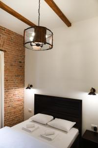 een slaapkamer met een bed en een kroonluchter bij Contessa Central Studio in Cluj-Napoca