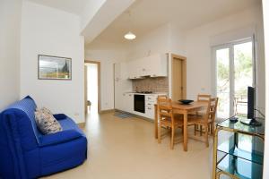 a living room with a blue couch and a table at Case Sangiorgio in Ginosa Marina