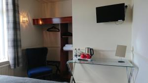 Habitación de hotel con escritorio y TV en geordie pride lodge en Liversedge