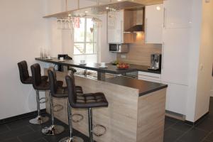 a kitchen with a counter and bar stools at 5*Ferienwohnung Seebrise 1 in Wendisch Rietz