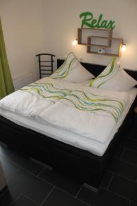 uma cama grande num quarto com uma placa na parede em 5*Ferienwohnung Seebrise 1 em Wendisch Rietz