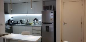 a kitchen with a stainless steel refrigerator and a table at Vistas in Punta del Este