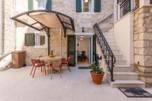 un patio con una mesa y sillas y una escalera en Apartments and Rooms Villa Erede, en Split