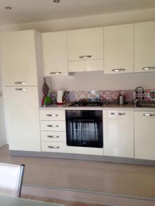 een keuken met witte kasten en een oven bij Appartamento Antonio in Malo