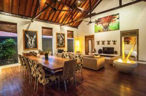 ein Wohnzimmer mit einem großen Holztisch und Stühlen in der Unterkunft Seminyak Villa in Seminyak