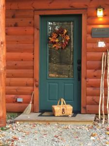 Una puerta verde en una casa con una corona. en Robert Frost Mountain Cabins, en Middlebury