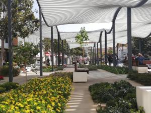 a walkway with benches and flowers in a mall at Kristal in Torremolinos