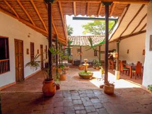 une cour intérieure avec des plantes en pot dans un bâtiment dans l'établissement Nacuma Garden Hostel - Casa Nacuma, à Barichara