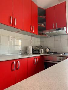 une cuisine avec des placards rouges et un comptoir dans l'établissement Pansion Villa Bubalo, à Mostar