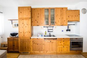 una cocina con armarios de madera y fregadero en Apartment Katarina Kranjska Gora, en Kranjska Gora