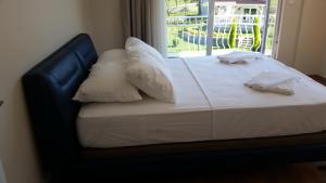 a bed with white sheets and pillows and a window at PALACE KIRKPINAR in Sakarya +119 photos