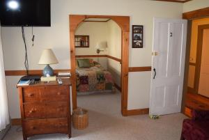 a bedroom with a bed and a dresser and a television at Black Lantern Inn in Montgomery Center