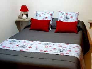1 dormitorio con 1 cama con almohadas rojas en casazul, en Palmeira