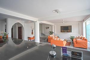 ein Wohnzimmer mit orangefarbenen Stühlen und einem Sofa in der Unterkunft Hotel La Ría Playas in Playas