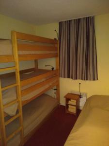 ein Schlafzimmer mit einem Etagenbett mit einer Leiter und einem Schreibtisch in der Unterkunft Ski Arcs 1800 Ruitor in Arc 1800