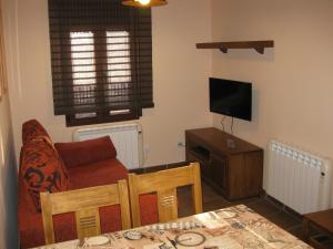 sala de estar con sofá y TV en Casa Artigot en Gea de Albarracín