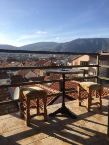 a table and two chairs on a balcony with a view at Apartments & Hostel Zdrava Hrana in Mostar