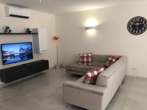 A television and/or entertainment centre at Marsascala Sea View Apartment HPI 7738