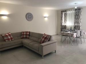 een woonkamer met een bank en een tafel bij Marsascala Sea View Apartment HPI 7738 in Marsaskala