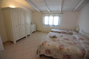 1 dormitorio grande con 2 camas y ventana en Cielo e mare, en Golfo Aranci