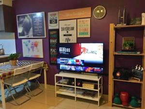 una habitación con TV, mesa, mesa y un tvictericter en The ComfyHauz # Cyberjaya en Cyberjaya