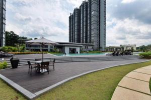 a patio with tables and an umbrella and buildings at The ComfyHauz # Cyberjaya in Cyberjaya