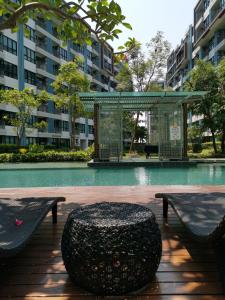 5 Floor - Centrio Condominium in Phuket Town - 30 mins to beaches في فوكيت تاون: وجود صخرة سوداء كبيرة للجلوس بجوار كرسيين