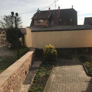 eine Backsteinmauer neben einem Haus in der Unterkunft Ferme Typique Alsacienne in Truchtersheim