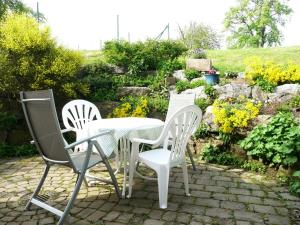 - une table et des chaises blanches sur la terrasse dans l'établissement ferien-domizil-schneider, à Uhldingen-Mühlhofen