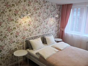a bedroom with a bed with floral wallpaper at Spacious apartment close to the Old Town in Vilnius