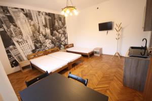 a room with two beds and a table and a tv at Żwirki in Częstochowa