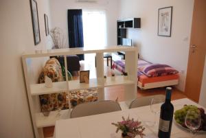 a dining room with a table with a bottle of wine at Apartmani Radin in Poreč