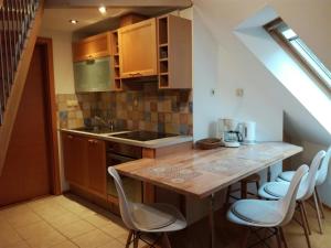 una cucina con tavolo in legno e sedie bianche di Apartments Dvor a Bovec