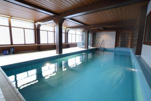 a large swimming pool in a building with windows at Haus Krick in Alpirsbach
