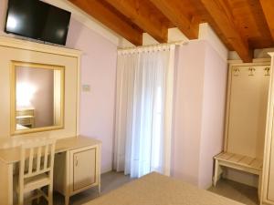 a bedroom with a vanity and a mirror and a window at Villa Serena Agriturismo in Montebelluna