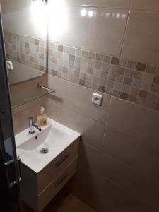 La salle de bains est pourvue d'un lavabo et d'un miroir. dans l'établissement Pokoje u Danki, à Gdynia