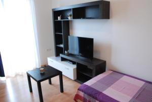 a bedroom with a tv and a bed and a table at Apartmani Radin in Poreč