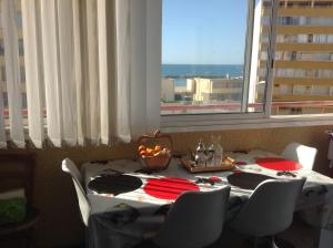 a table with a bowl of fruit on it in front of a window at Résidence CAP HORN ,13 ter Avenue des Élysées in Valras-Plage