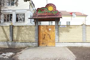 - un bâtiment avec un panneau et une porte en bois dans l'établissement Zhyttedar, à Ulanov