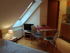 a bedroom with a bed and a desk with chairs at Apartments Dvor in Bovec