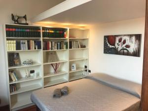 um quarto com uma cama e estantes de livros com livros em Il Cuore di Bologna em Bolonha