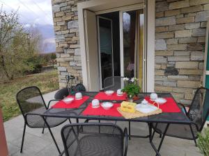 a black table with red napkins on a patio at "Lake & Mountain" Summer House in Colico