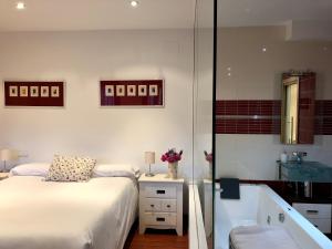 a bedroom with a bed and a bath tub and a sink at Casa rural Laguna de Uña in Uña +32 photos
