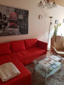 ein Wohnzimmer mit einem roten Sofa und einem roten Doppeldeckerbus in der Unterkunft Ferienwohnung Brinkmann 4**** mit Moselblick in Dieblich